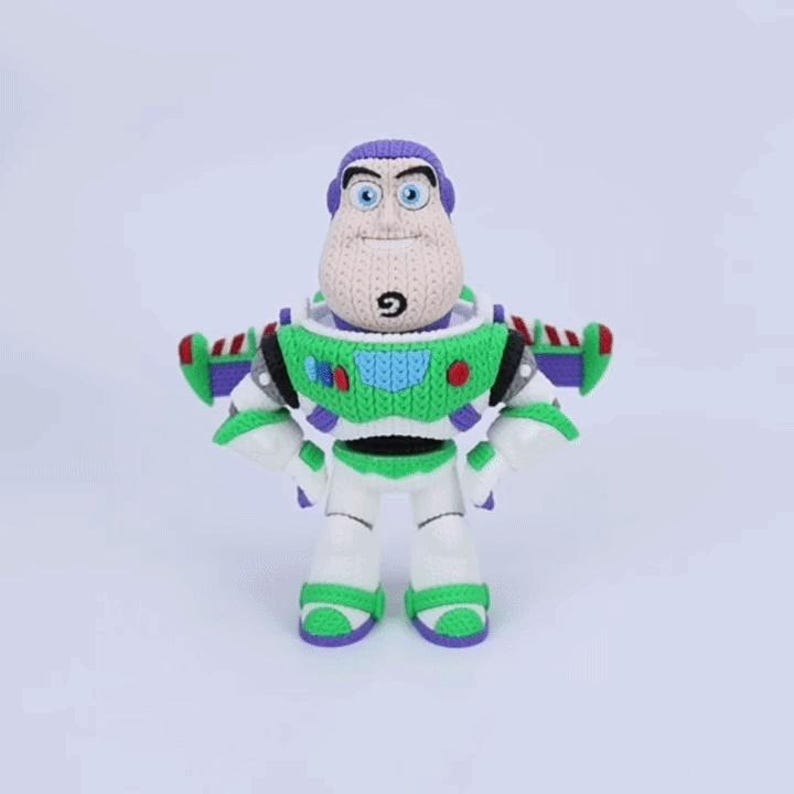 May include: A crocheted plush figure of a space ranger character with a purple hood, a white face, and a green and white chest plate. The figure features blue eyes, a small chin goatee, and purple wings extending from the back of the suit.