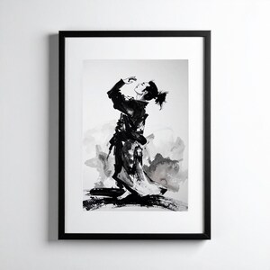 Op de afbeelding: Zwart-wit inktwassing schilderij van een persoon in een kimono, ingelijst in een zwart frame. De figuur knielt, met de armen omhoog, en heeft een knot. De achtergrond bevat abstracte inktwassingen.