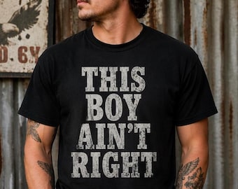 May include: Black t-shirt with the text "THIS BOY AIN'T RIGHT" in distressed white lettering. The shirt is short-sleeved and has a crew neck. The image shows the shirt on a person.