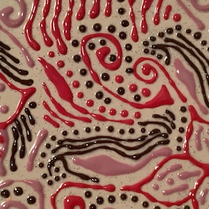 May include: Abstract art piece with a textured, off-white background. The artwork features a variety of shapes and patterns in shades of red, pink, and brown. The design includes dots, swirls, and flowing lines, creating a dynamic and colorful composition.