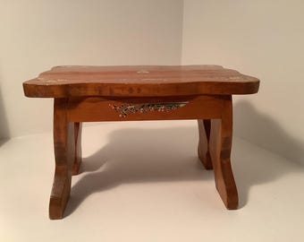 Taburete de madera de estilo danés vintage con diseños florales y figura de mujer.