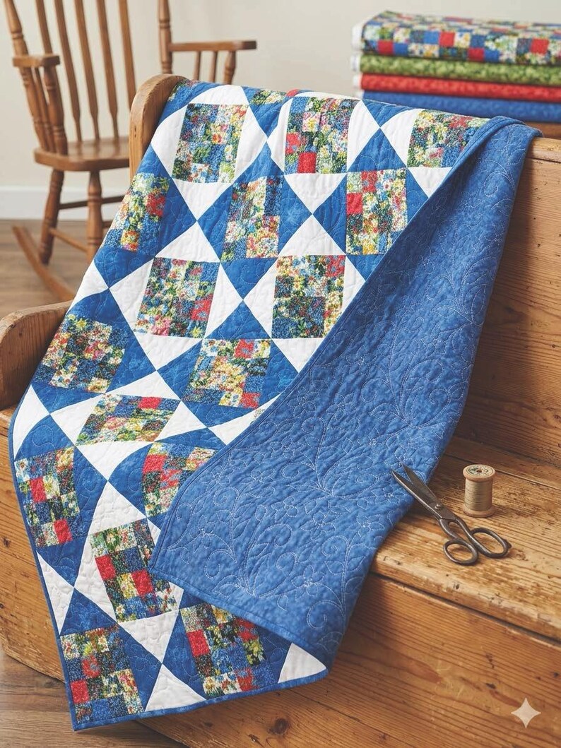 May include: A handmade quilt with a blue and white geometric pattern. The quilt features floral squares and a solid blue backing. A pair of scissors and thread are on the wooden surface.