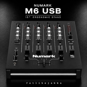 Könnte beinhalten: Ein schwarzer Numark M6 USB DJ-Mixer auf einem ergonomischen 15-Grad-Ständer. Das Gerät verfügt über mehrere vertikale Fader, Drehregler und Eingangskontrollen. Der Text Numark M6 USB 15 DEGREE ERGONOMIC STAND ist über dem Mischpult zu sehen.