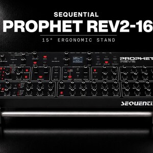 May include: A black Sequential Prophet Rev2-16 synthesizer featuring wooden side panels, numerous knobs, and a digital display, mounted on a 15-degree ergonomic stand. The text Sequential Prophet Rev2-16 and 15-degree ergonomic stand is visible.