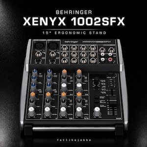 Könnte beinhalten: Behringer XENYX 1002SFX Audiomischpult mit 15-Grad-Ergonomieständer. Die schwarze Konsole verfügt über mehrere Eingangskanäle mit blauen, orangefarbenen und weißen Drehreglern, XLR- und Line-Eingängen sowie einen Hauptfader auf der rechten Seite.