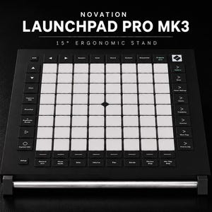 Może przedstawiać: Czarny kontroler MIDI Novation Launchpad Pro MK3 z siatką 8x8 białych kwadratowych padów, otoczony czarnymi przyciskami funkcyjnymi z białymi etykietami, zamontowany na ergonomicznym stojaku o nachyleniu 15 stopni ze srebrnym metalowym wspornikiem.