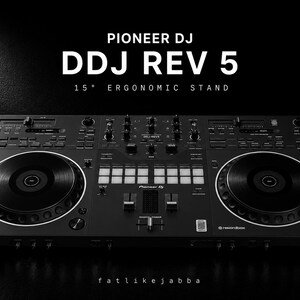 Pode incluir: Um controlador Pioneer DJ DDJ REV 5 preto com dois grandes jog wheels, uma secção de misturador central com pads de desempenho, faders e botões. O texto PIONEER DJ DDJ REV 5 15° ERGONOMIC STAND é exibido acima da unidade, com logótipos serato e rekordbox.
