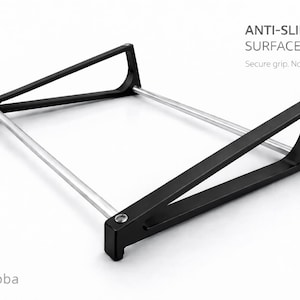 Puede incluir: Un soporte de metal negro con dos marcos laterales triangulares conectados por dos varillas horizontales plateadas. El texto ANTI-SLIP SURFACE Secure grip. No slipping. es visible arriba a la derecha, y el texto fatlikejabba est&aacute; abajo a la izquierda.