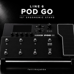 以下が含まれることがあります： 15度の人間工学に基づいたスタンドを備えた黒いLine 6 Pod Goギタープロセッサーユニット。このデバイスには、上部ディスプレイ画面、複数のコントロールノブ、A、B、C、D、Mode、Tapとラベル付けされた8つの円形フットスイッチ、およびサイドエクスプレッションペダルが含まれています。