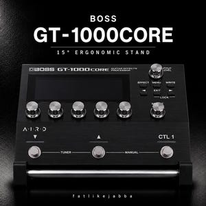 以下が含まれることがあります： 15度の人間工学に基づいたスタンドに設置された黒いBOSS GT-1000COREギターエフェクトプロセッサー。中央のディスプレイ画面、5つの銀色のコントロールノブ、Tuner、Manual、CTL 1とラベル付けされた3つのフットスイッチ、および追加のナビゲーションボタンを備えています。
