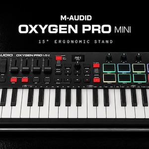 Op de afbeelding: M-Audio Oxygen Pro Mini MIDI-keyboardcontroller met 25 toetsen, acht verlichte performance-pads, vier toewijsbare knoppen, vier faders en een centraal OLED-scherm. Het apparaat is geplaatst op een ergonomische standaard van 15 graden.