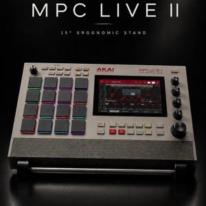 May include: An Akai Professional MPC Live II music production centre on a 15-degree ergonomic stand. The device features a grid of sixteen black square pads with colourful LED borders, a central touchscreen display, and various control buttons and knobs.