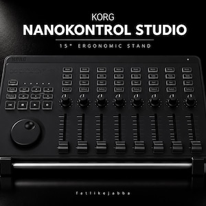 Può includere: Un controller MIDI Korg nanoKONTROL Studio nero posizionato su un supporto ergonomico a 15 gradi. Il dispositivo presenta otto fader, otto manopole rotanti, una rotella di scorrimento e vari pulsanti di trasporto. Il testo KORG NANOKONTROL STUDIO 15 DEGREE ERGONOMIC STAND è visibile sopra l'unità.