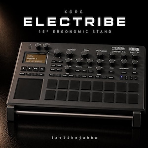 Puede incluir: Un sintetizador de producción musical Korg Electribe negro sobre un soporte ergonómico de 15 grados. El dispositivo presenta numerosas perillas y botones, y una pequeña pantalla que muestra "Magician 1". El logotipo de Korg es visible, junto con el texto "Electribe".