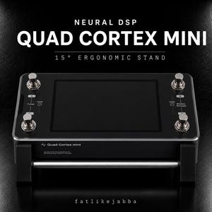 May include: A black Neural DSP Quad Cortex Mini 15 degree ergonomic stand featuring a central rectangular screen, four metallic footswitches, and printed labels including Tuner, Modes, and Presets. The device is mounted on a silver horizontal bar.