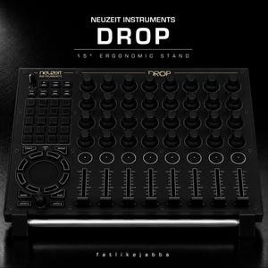 Könnte beinhalten: Ein schwarzer, ergonomischer 15-Grad-Ständer Neuzeit Instruments Drop mit einem Raster aus Drehreglern, einem kreisförmigen Touchpad, mehreren Fadern und einer Tastenmatrix. Das Gerät ist mit Neuzeit Instruments, Drop und fatlikejabba beschriftet.