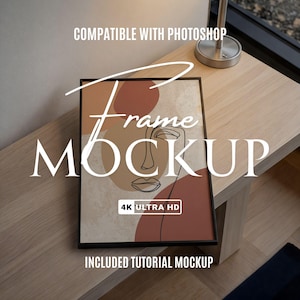 May include: A black framed art print mockup with abstract face art in shades of brown and beige. The words "Frame Mockup" are displayed in white, along with "4K Ultra HD" and other text. The frame rests on a wooden table.