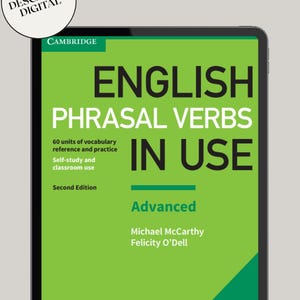 Peut inclure: Une tablette numérique affiche la couverture de "English Phrasal Verbs in Use", une publication de Cambridge. La couverture du livre est principalement verte avec du texte blanc en gras. Le titre, "English Phrasal Verbs in Use", est bien en évidence, avec le mot "Advanced."