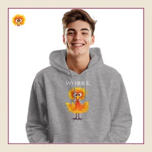 Könnte beinhalten: Ein grauer Kapuzenpullover mit dem Wort "WORKS." über einer Cartoon-Vogel-Illustration in Gelb, Orange und Rot. Der Kapuzenpullover hat eine Kapuze mit Kordelzug und eine Kängurutasche.
