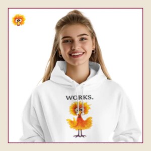 Könnte beinhalten: Weißer Kapuzenpullover mit dem Aufdruck „WORKS.“ auf der Vorderseite. Darunter befindet sich eine Cartoonfigur mit gelben und orangefarbenen Federn. Die Person trägt den Kapuzenpullover.