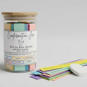 May include: A glass jar with a wooden lid, labeled "Confirmation Jar" with a dove illustration. The jar contains colorful paper squares. Beside the jar are colorful strips of paper and a white heart-shaped object.