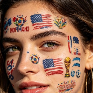 May include: A woman's face decorated with temporary tattoos of footballs, American flags, a trophy, and the word "Champion." The tattoos are in red, white, blue, and gold.