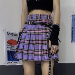 Pleated Mini Skirt | Casual Ruffle Plaid Fashion | Streetwear Grunge Outfit

Woman wearing a layered pleated mini skirt with plaid design and ruffle details, styled in a grunge Y2K streetwear outfit.
