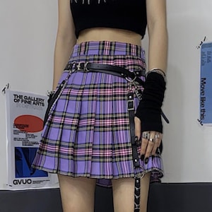 Pleated Mini Skirt | Casual Ruffle Plaid Fashion | Streetwear Grunge Outfit

Woman wearing a layered pleated mini skirt with plaid design and ruffle details, styled in a grunge Y2K streetwear outfit.