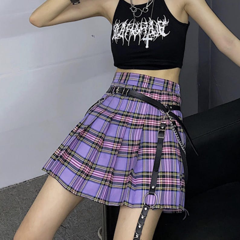 Pleated Mini Skirt | Casual Ruffle Plaid Fashion | Streetwear Grunge Outfit

Woman wearing a layered pleated mini skirt with plaid design and ruffle details, styled in a grunge Y2K streetwear outfit.