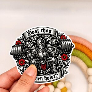 Puede incluir: Una pegatina con un caballero con armadura levantando una barra, con el texto "Dost thou even hoist?" El dise&ntilde;o es en blanco y negro con detalles florales rojos. El caballero est&aacute; en cuclillas.