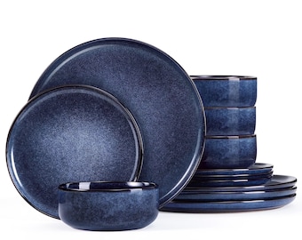 May include: A complete dinnerware set featuring a deep blue speckled glaze. The set includes various sized plates and bowls, with a dark rim. The plates are stacked, and the bowls are in a neat pile, all against a white background.