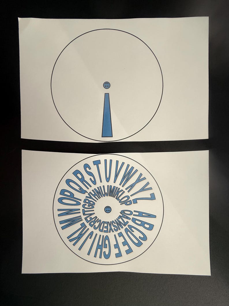 Op de afbeelding: Twee witte papieren uitsparingen. De bovenste uitsparing heeft een zwarte cirkel met een blauwe uitroeptekenvorm erin. De onderste uitsparing heeft een cirkel met het alfabet in blauwe letters.