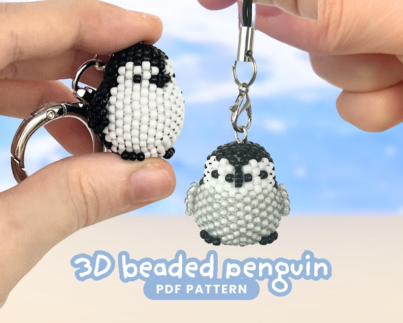 May include: Two 3D beaded penguin charms made from small black, white, and grey seed beads. One penguin is attached to a silver metal keyring, and the other hangs from a black cord with a silver lobster clasp. Text reads 3D beaded penguin PDF pattern.