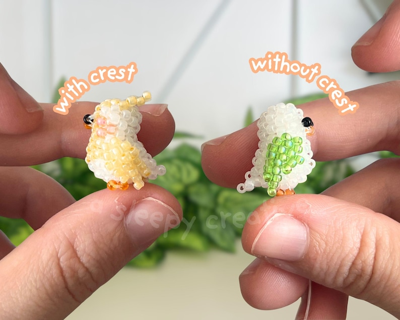 May include: Two miniature bird figurines crafted from small beads. The left bird is yellow and white with a crest, labeled 'with crest'. The right bird is white with green wing details and no crest, labeled 'without crest'. Both have black eyes.