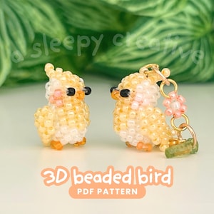May include: Two beaded bird figurines in yellow, orange, and pink. One bird is a keychain. The text "3D beaded bird PDF pattern" is displayed in the image. The birds are set against a background of green leaves.