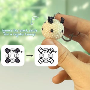 May include: A spherical beaded charm featuring a white base with black spots and small black ears, attached to a metal keyring. The image includes a diagram showing bead placement and text that reads: ignore the black spots for a regular bunny!