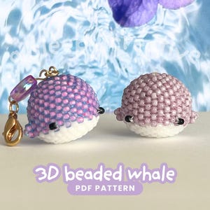 May include: Two beaded whale figurines. One whale is purple and white with a gold clasp and charm. The other whale is purple and white. The text "3D beaded whale PDF pattern" is at the bottom of the image.