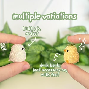 May include: Two miniature bird figurines, one white with a bird beak and the other yellow with a duck beak and leaf accessory. The text "multiple variations" and other descriptive text is also visible.