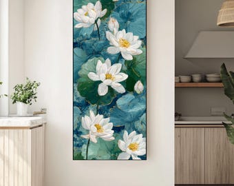 Puede incluir: Lienzo vertical con flores de loto blancas con centros amarillos y hojas verdes sobre un fondo azul y turquesa. La obra de arte está enmarcada en negro, ideal para cualquier espacio.