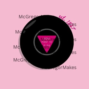 May include: A black Magic 8-Ball with a pink triangle displaying the text "SIGNS POINT TO PI PHI". The ball is set against a pink background with the text "McGregor Makes" and "est. 1867".