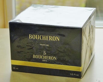 May include: A black Boucheron Parfum box with gold lettering and accents. The box is wrapped in clear plastic and features the brand name, product type, and volume information: 15 ml and 1/2 fl oz.