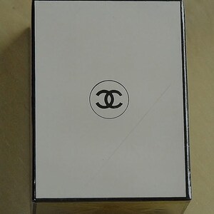 May include: Rectangular white box with a black border and a black double-C logo in the center. The box has a gold-colored base and is likely a product package.