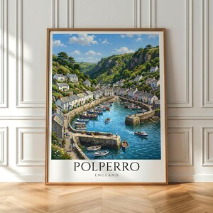 May include: A framed wall art print depicting the coastal village of Polperro, England. The scene features a harbor filled with small boats, surrounded by white cottages nestled into green hills under a blue sky. The text reads POLPERRO ENGLAND.