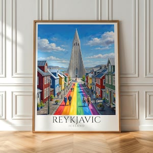 May include: A framed art print featuring a street scene in Reykjavik, Iceland, with a rainbow-colored road leading to a tall, pointed church. The image includes colorful houses on both sides, people walking, and the text REYKJAVIC ICELAND at the bottom.
