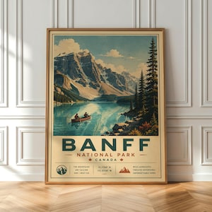 Peut inclure: Une affiche de voyage vintage encadrée pour le parc national Banff, au Canada. L'affiche présente une scène de lac avec des montagnes, un canoë et des arbres à feuilles persistantes. L'affiche porte le texte "Banff National Park Canada".