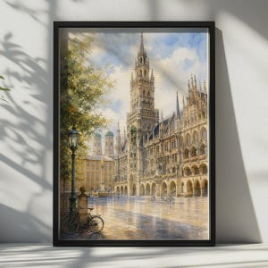 Peut inclure: Une peinture à l'aquarelle encadrée représentant le nouvel hôtel de ville de Munich, en Allemagne. La scène montre l'architecture gothique ornée du bâtiment, une haute tour d'horloge, un lampadaire, un vélo au premier plan et un ciel bleu nuageux.
