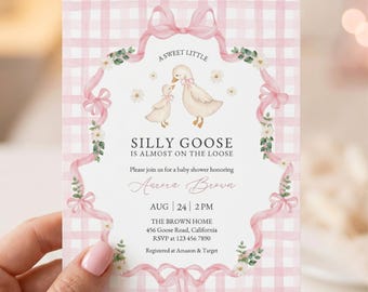 Puede incluir: Una invitación a un baby shower con un fondo de cuadros rosas y un borde decorativo de cinta. La invitación presenta una ilustración de dos gansos y el texto "Silly Goose is Almost on the Loose".