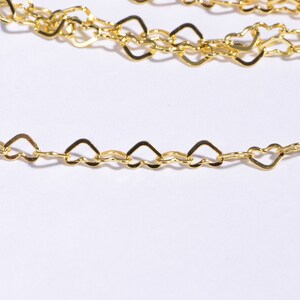 May include: A gold chain necklace with heart-shaped links. The chain is delicate and has a polished finish.