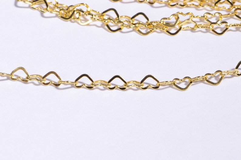May include: A gold chain necklace with heart-shaped links. The chain is delicate and has a polished finish.