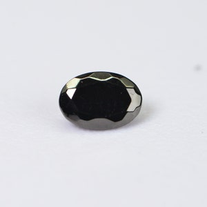 May include: A black oval-shaped gemstone with a faceted cut.